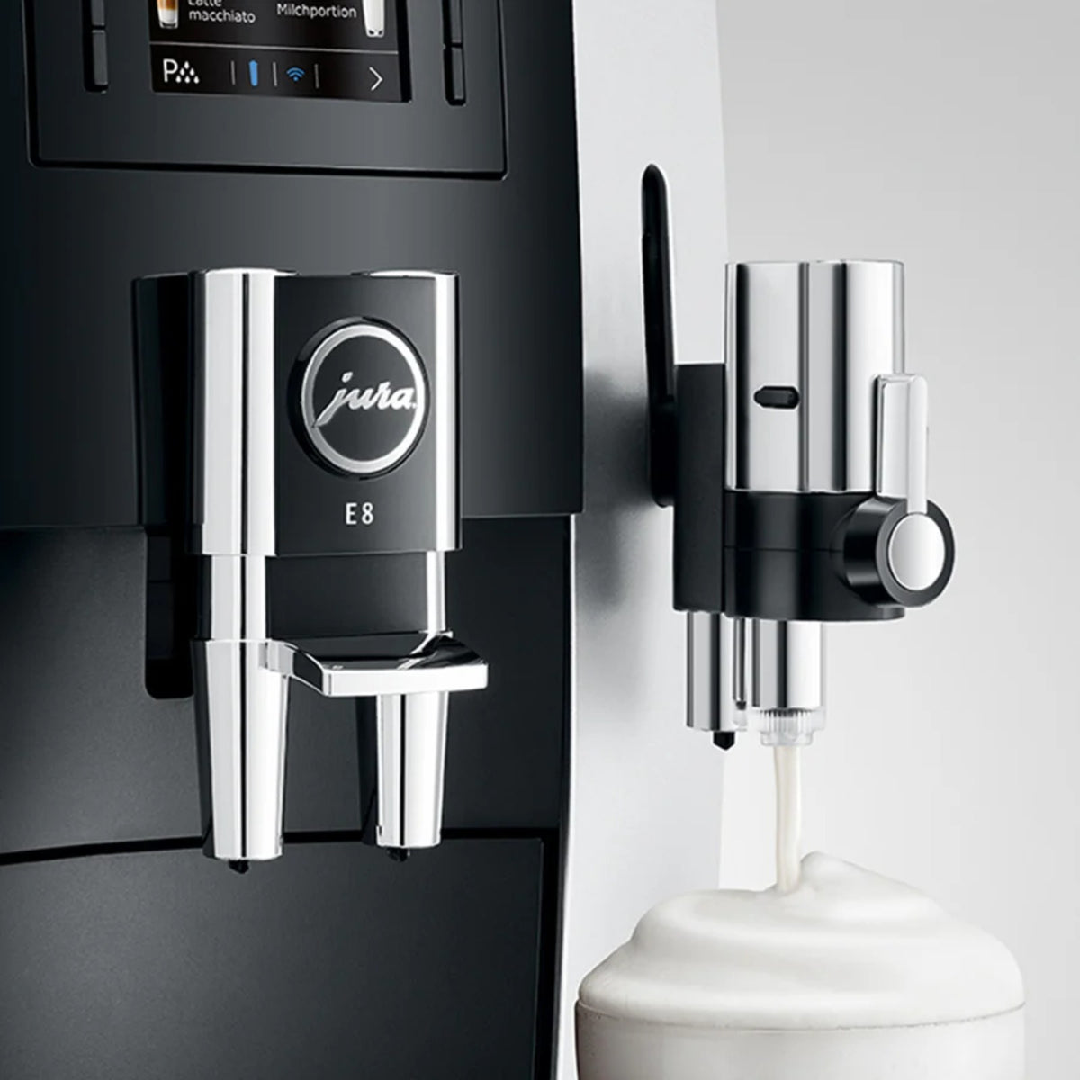 JURA Professional fine‑foam nozzle G2 (24250) connected to a coffee machine, chrome adapter and stream of milk foam into a container