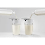 JURA Milk container EA (24313) – two white cylindrical containers with transparent striping and milk being poured into open lids