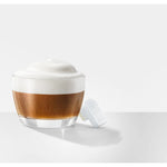 JURA WiFi Connect V2 (24323) biely modul položený vedľa pohára s cappuccinom, hore pena
