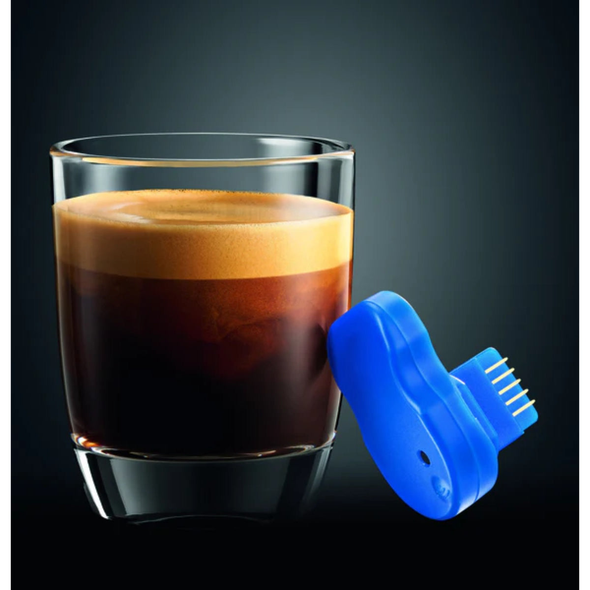 JURA Smart Connect module (72167) blue module with connectors next to an espresso glass with crema