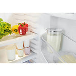 JURA Glass milk container (72570) in refrigerator with silver lid and jura inscription, next to vegetables and yogurts