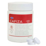 White plastic canister Urnex Cafiza E31 with red label and three white cleaning tablets beside it